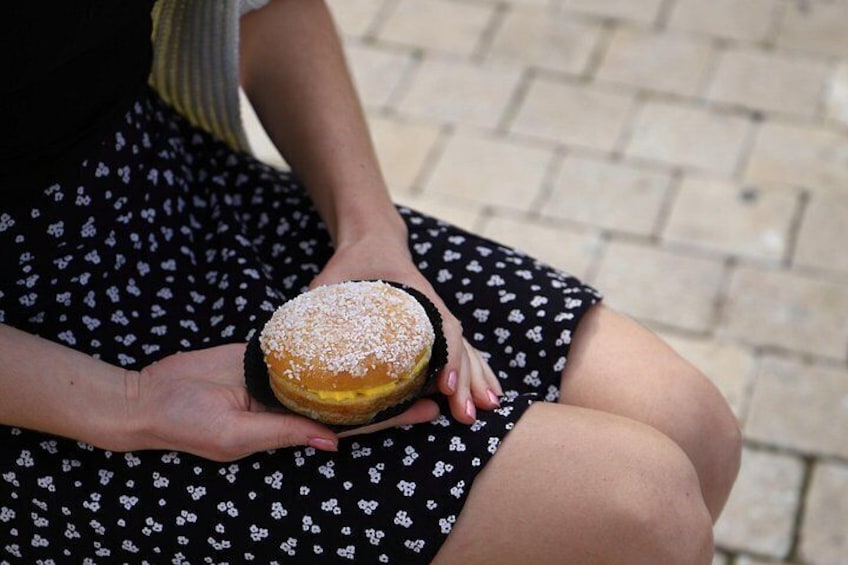 A person holding a powdered donut. 2