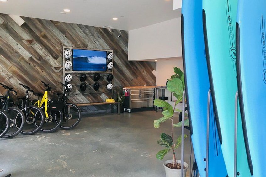 A modern indoor space with a wooden wall, a mounted television, and several bicycles. 5
