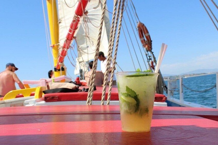 A drink on a boat with a red and yellow deck, ropes, and a lifebuoy in the background. 4