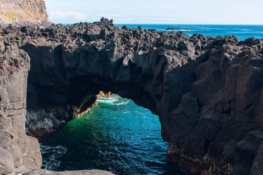 A natural rock arch formation over a body of water. 2
