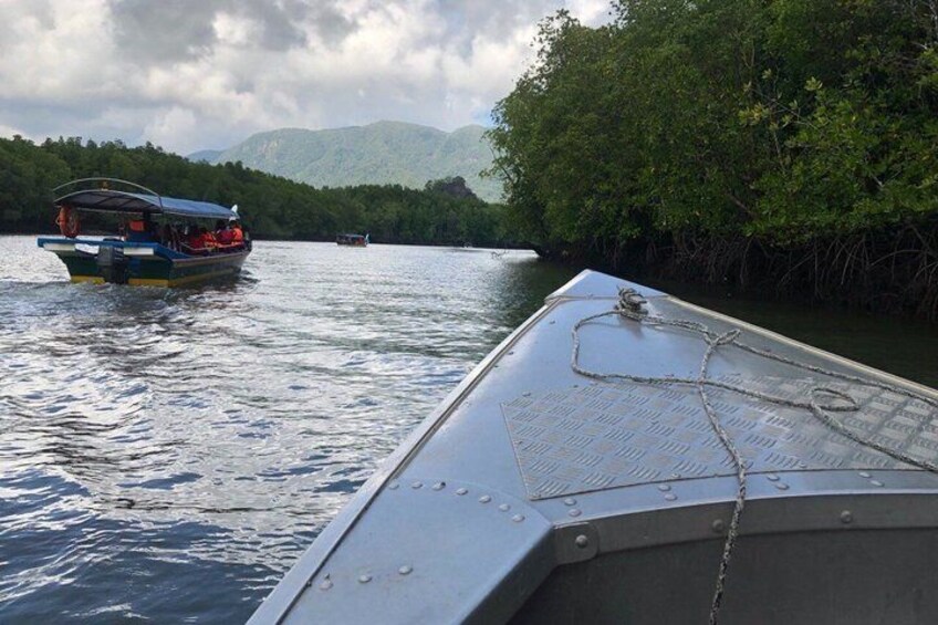 A boat on a calm river with a forested landscape in the background. 5