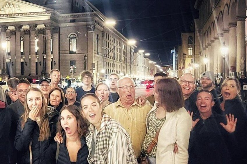 Un gruppo di persone riunite in una strada cittadina di notte. 4