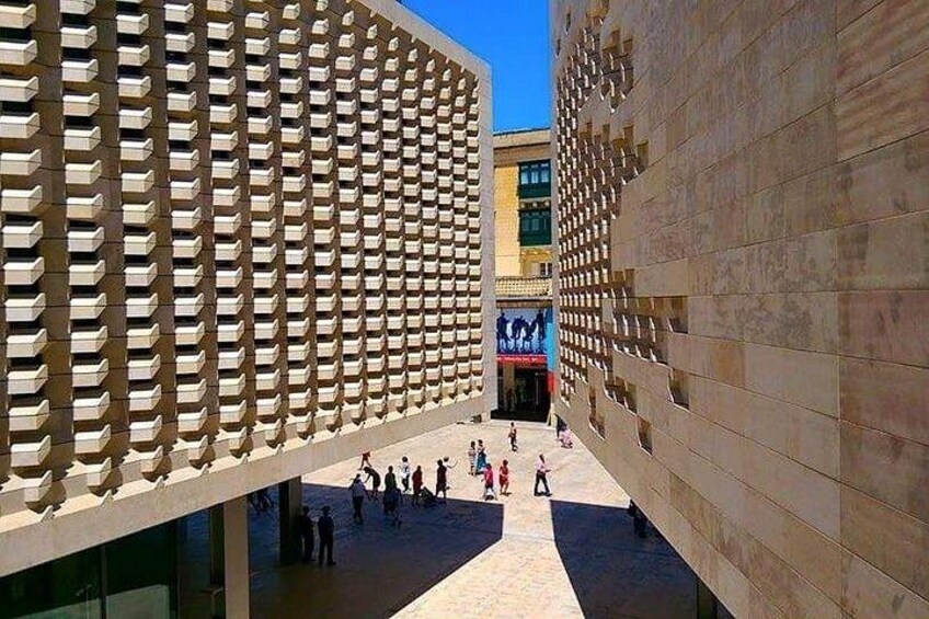 A modern architectural structure with a grid-like facade and a central open space. 3