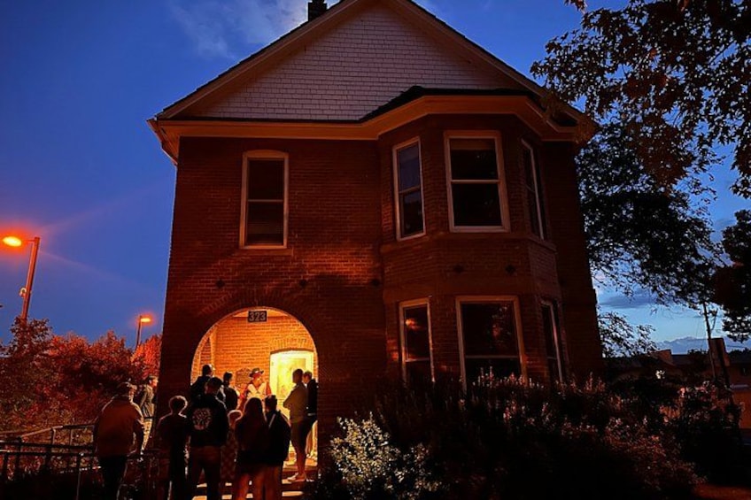 A brick building with a large arched doorway, surrounded by people. 5