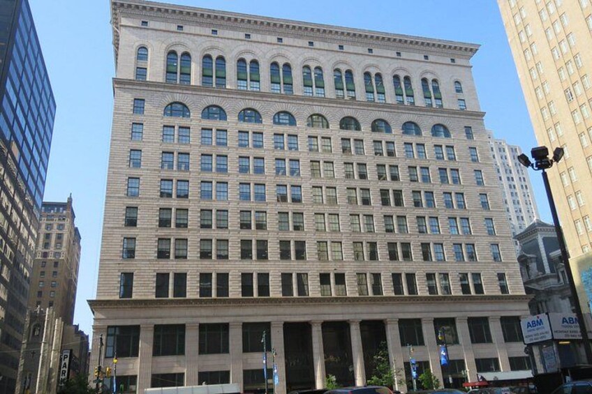 A large, multi-story building with a classical architectural style, featuring a symmetrical facade with evenly spaced windows and decorative elements. 2