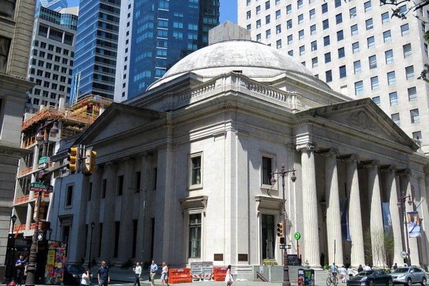 A classical building with columns and a dome, surrounded by modern high-rise buildings. 5