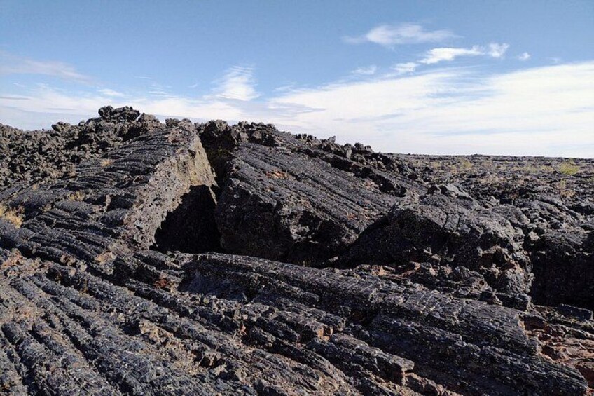 A volcanic landscape with rugged terrain and a prominent crater. 2