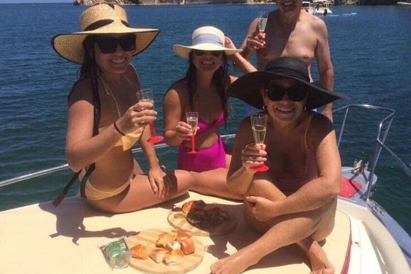 Een groep mensen op een boot, met drankjes en een bord eten. 4
