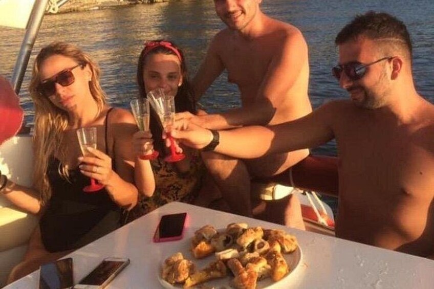 Een groep mensen op een boot, die met champagneglazen proosten, met een bord eten op de voorgrond. 5