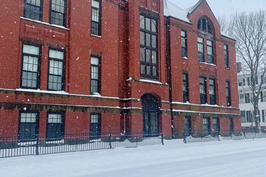 A red brick building with snow on the roof and ground. 2