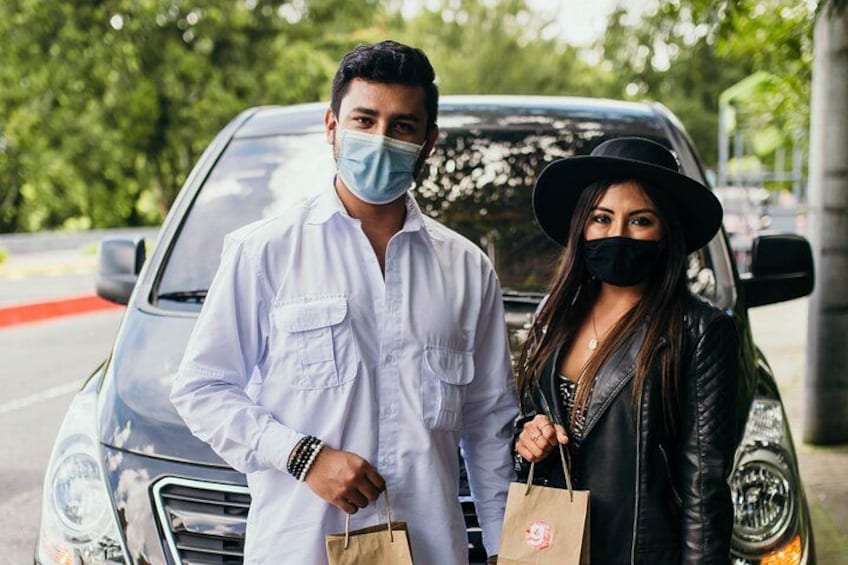 Ein Mann und eine Frau stehen vor einem Auto, beide tragen Masken. 5