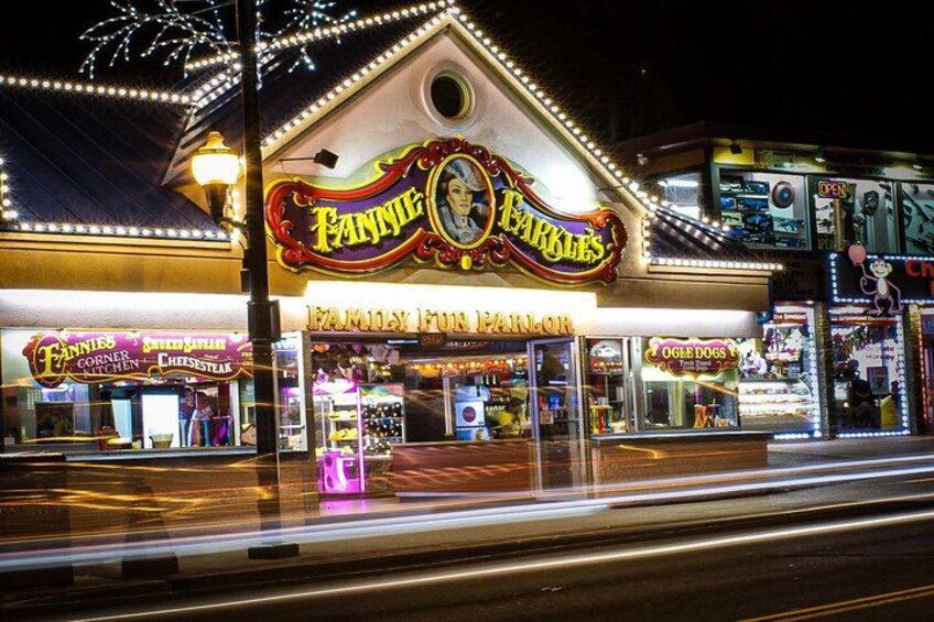 Un parco divertimenti ben illuminato con un cartello che recita 'Fannie's Corner' e 'Fannie's Fun Fair'. 4