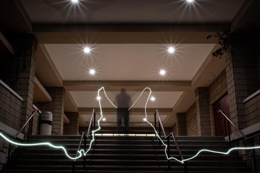 A staircase with a person ascending, surrounded by brick walls and recessed lighting. 5