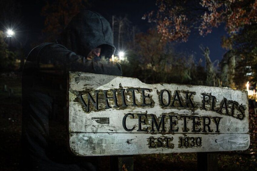 Un cartello consunto indica il cimitero di White Oak Flat, con la scritta 'ISTITUITO NEL 1830'. 3