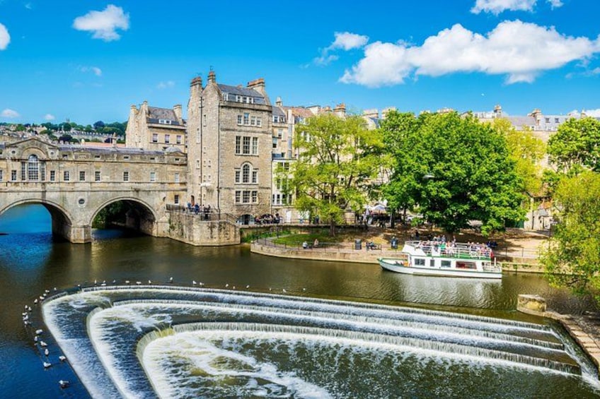 A river with a bridge, a boat, and a castle-like building. 1