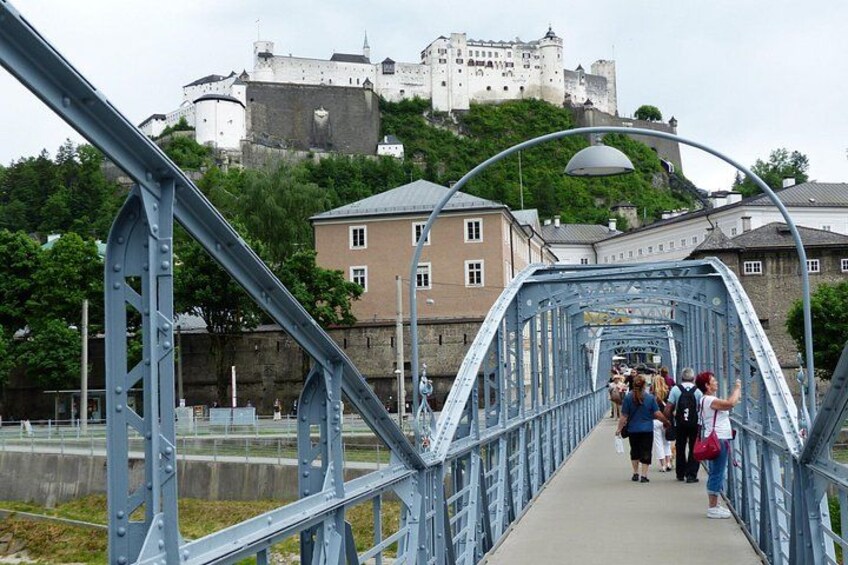 A pedestrian bridge with a castle in the background. 5