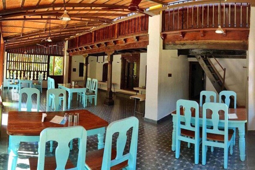 Un comedor interior con mesas de madera y sillas turquesas. 3