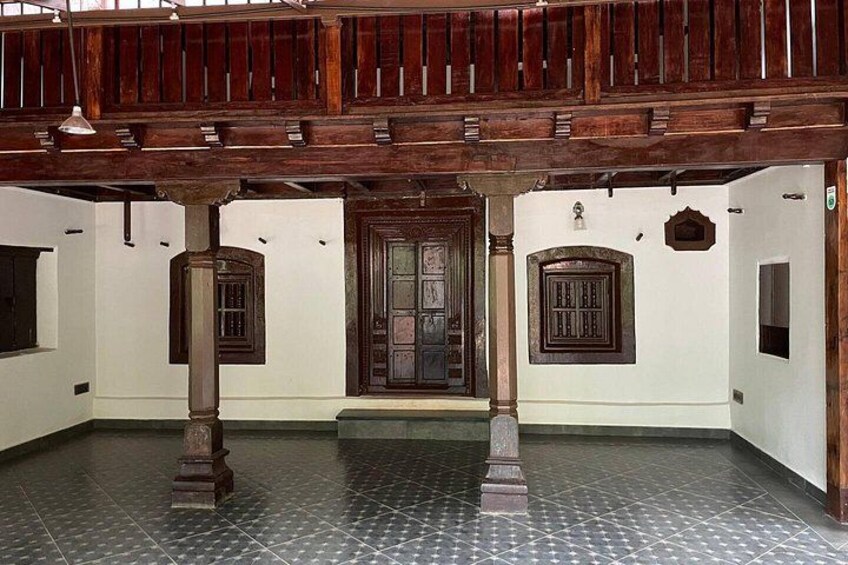 Un edificio tradicional con vigas de madera, suelo de baldosas y una puerta central. 4