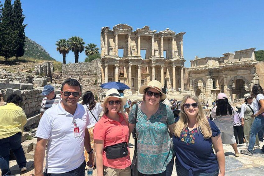 Un groupe de personnes se tient devant des ruines antiques, avec des colonnes et des arches. 2