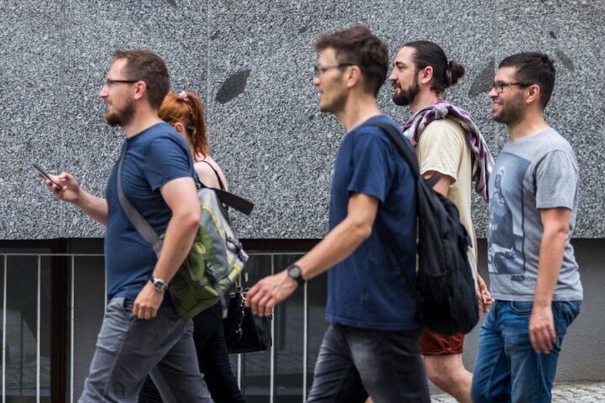 A group of people walking outdoors, some carrying backpacks. 2