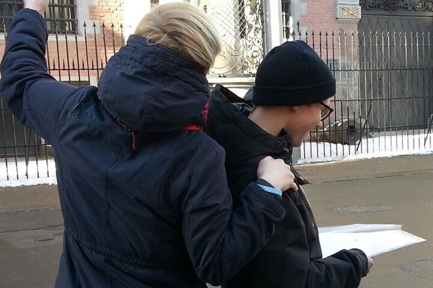 Two people walking on a street, one holding a piece of paper. 5