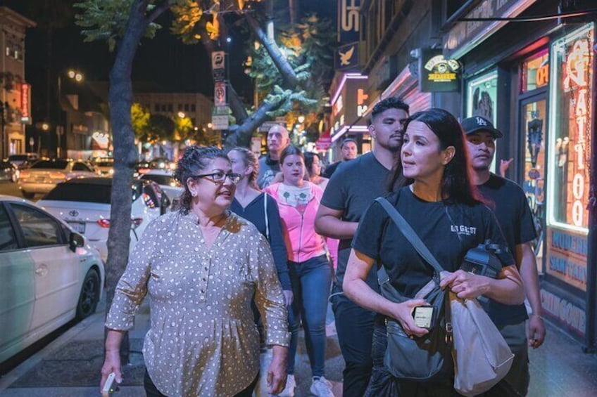 A group of people walking on a city street at night. 5