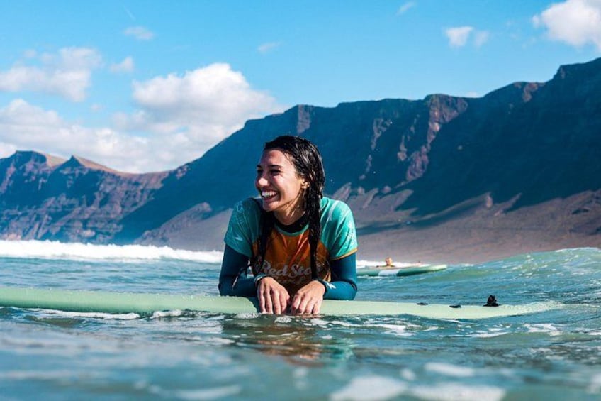 Una persona fa surf con un paesaggio montuoso sullo sfondo. 1