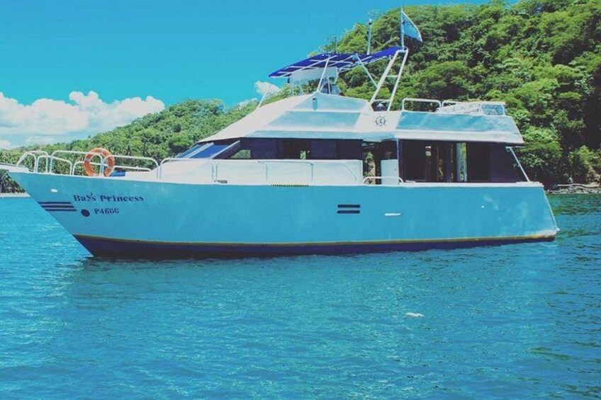 A boat named 'Ba's Princess' on a body of water with a forested island in the background. 1