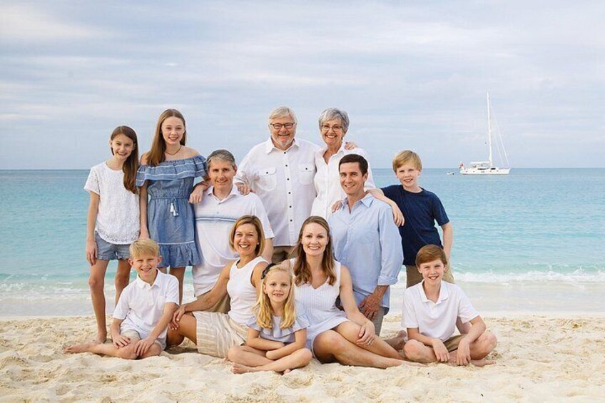 Una famiglia su una spiaggia, con una barca a vela sullo sfondo. 5