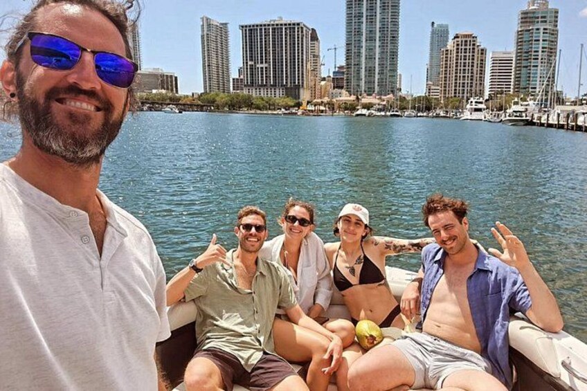 Un groupe de personnes se trouve sur un bateau, avec la silhouette d’une ville en arrière-plan. 2