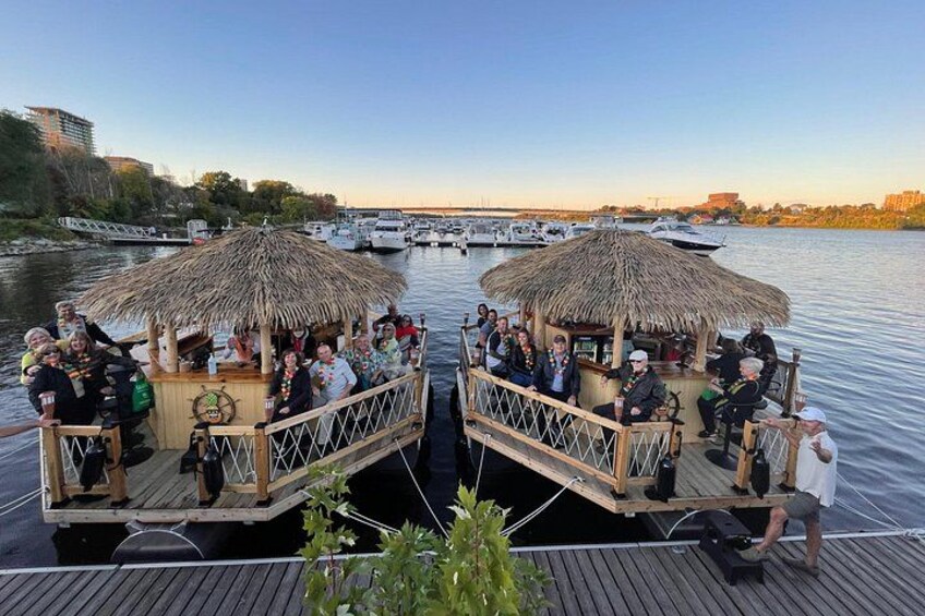 A boat with thatched-roof structures and people on deck. 1