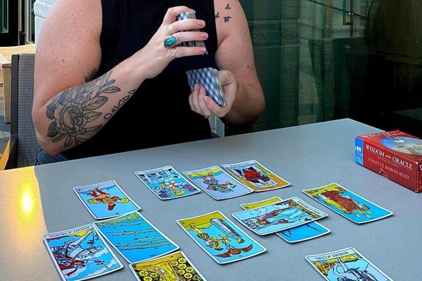 A person with a tattoo on their arm playing a tarot card game. 3