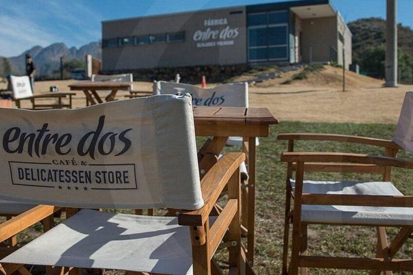Outdoor seating with a sign for 'entre dos CAFÉ & DELICATESSEN STORE'. 4