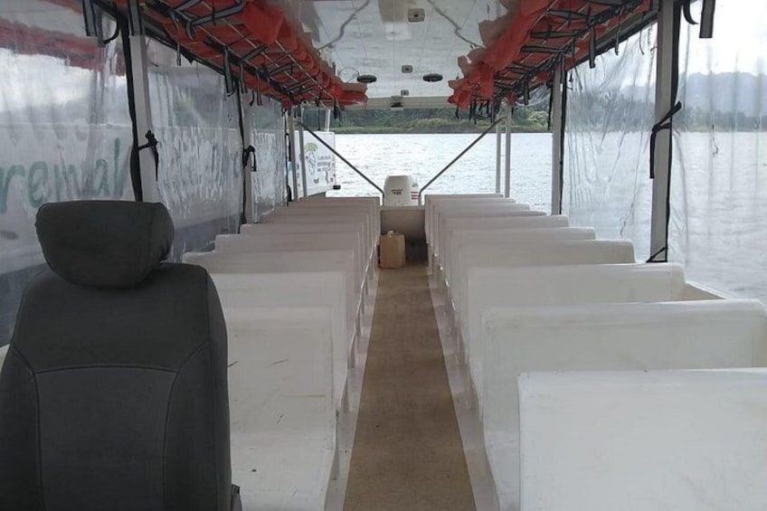 Bootinterieur met rijen witte stoelen en een grijze stoel op de voorgrond. 5