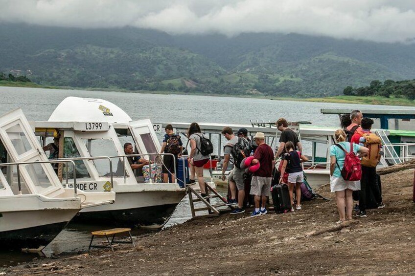 Een groep mensen stapt aan boord van een boot bij een steiger. 5