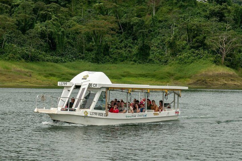 Een boot met passagiers op een rustige rivier, omgeven door groen. 5