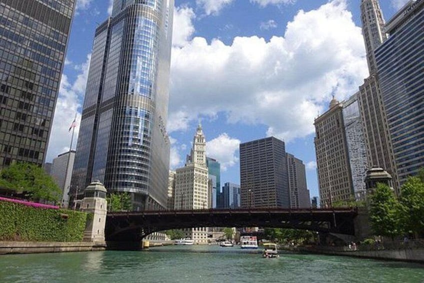 A river with a bridge, skyscrapers, and a boat. 2