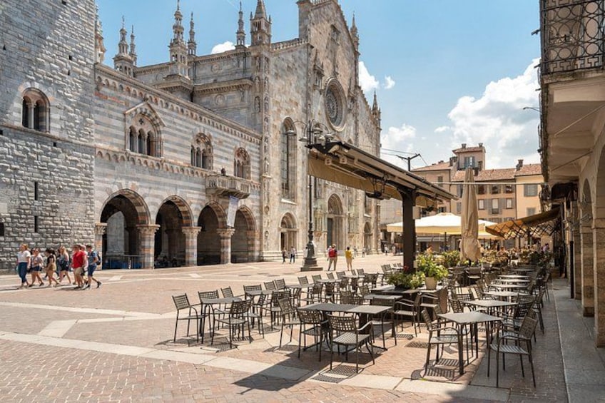 A historic plaza with outdoor seating and a grand cathedral in the background. 3
