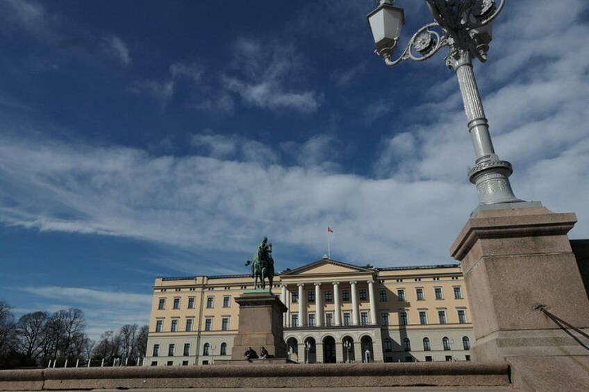 A large building with a statue on a pedestal, a flag on top, and a clear blue sky. 4