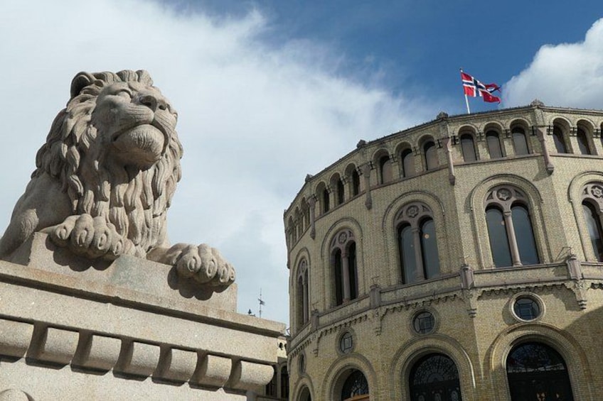 A lion statue, a building with arched windows, and a flag. 3