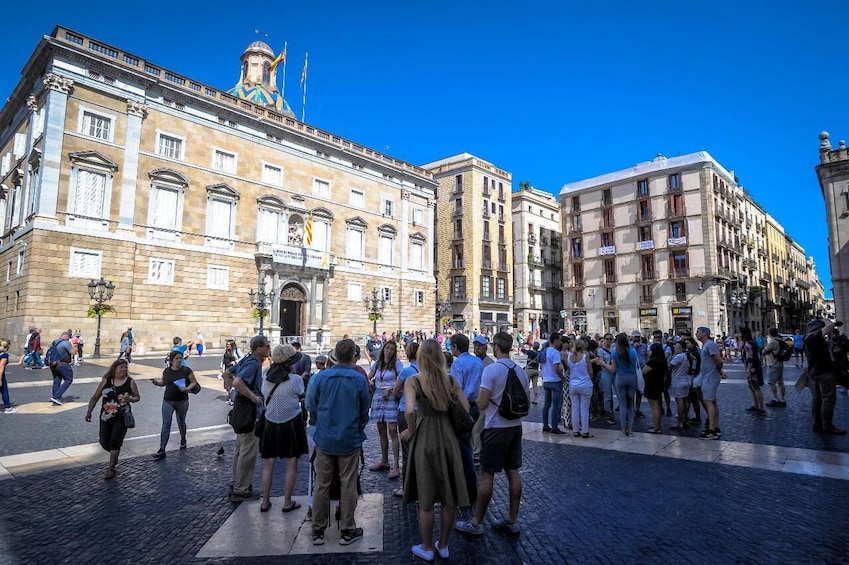 Una plaza animada con edificios históricos, una multitud de gente y un cielo azul despejado. 3