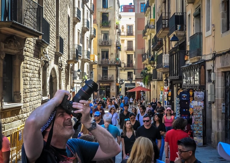 Una calle concurrida con gente caminando y un fotógrafo tomando fotos. 2
