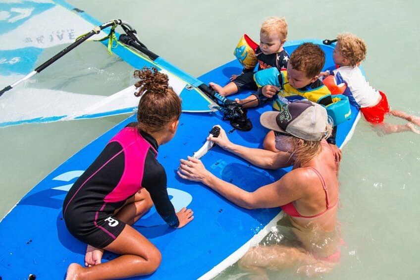 Un groupe de personnes se trouve sur un bateau bleu dans des eaux peu profondes, et elles portent toutes des gilets de sauvetage. 4