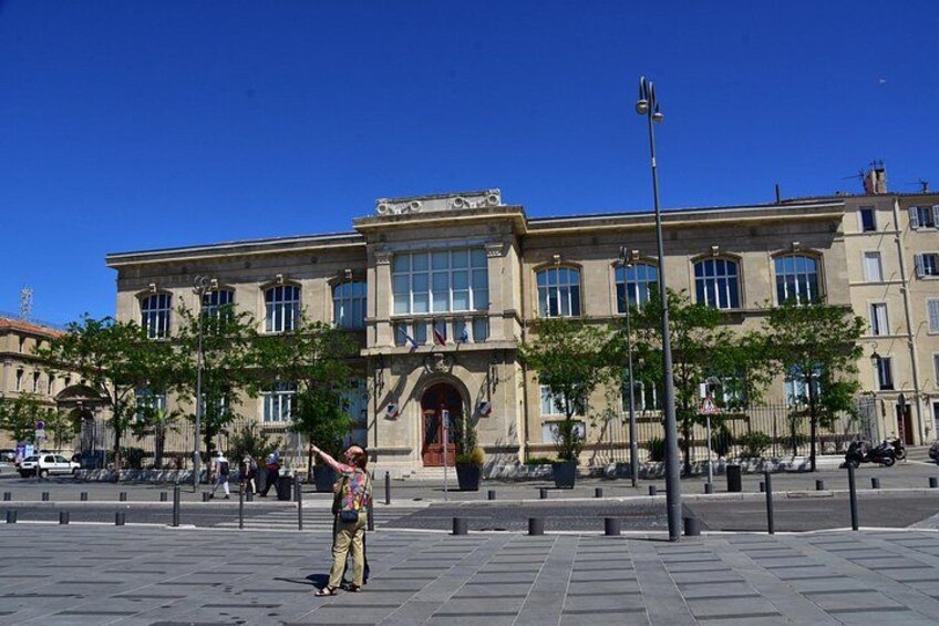 Eine Person steht auf einem Platz vor einem historischen Gebäude. 5