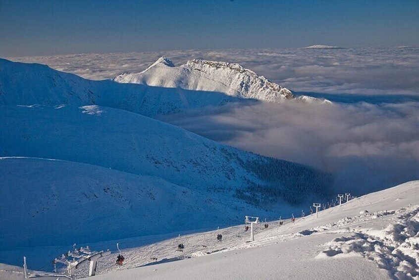A snow-covered mountain landscape with ski lifts and a clear sky. 1