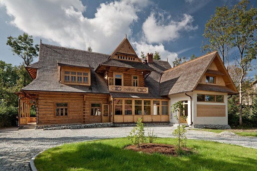 A large wooden house with a sloped roof, a garage, and a well-maintained lawn. 5