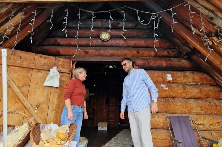 Una cabaña de madera con un interior rústico, una cesta de pan en el suelo y una lámpara colgante. 3