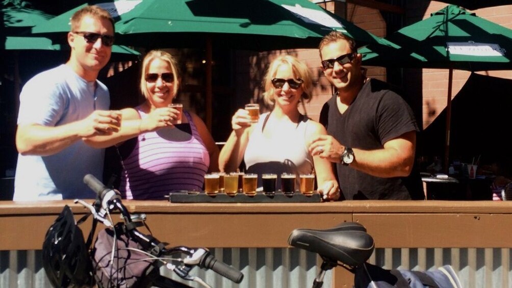 Two couples toasting with glasses of beer