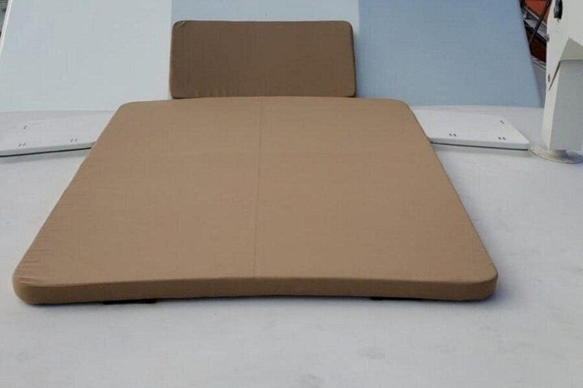 A brown mattress on a white surface. 5