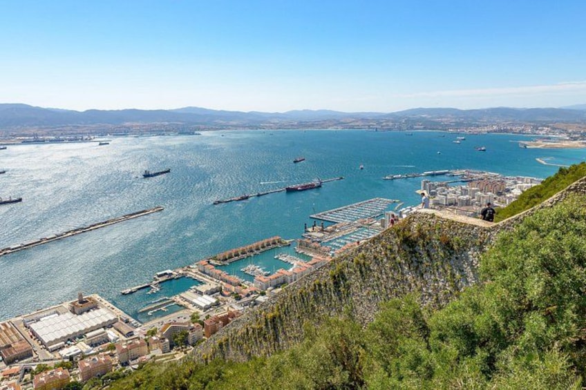 Paesaggio costiero con un porto turistico, barche e uno sfondo collinare. 3
